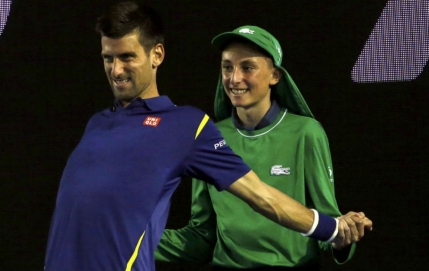 Imaginea zilei la Australian Open: Djokovic se intinde cu un copil de mingi